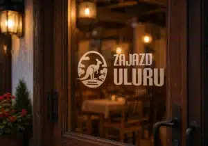 Logo Zajazdu Uluru umieszczone na przeszklonych drzwiach wejściowych restauracji i obiektu noclegowego w Lidzbarku Warmińskim.