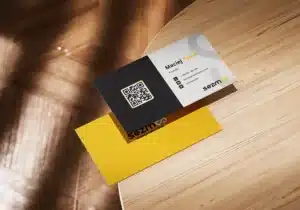 Projekt dwustronnej wizytówki agencji kreatywnej Sezmoo z kodem QR i danymi kontaktowymi.